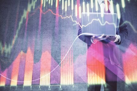 Forex graph with businessman working on laptop on background. Concept of hardworking. Multi exposure.の写真素材