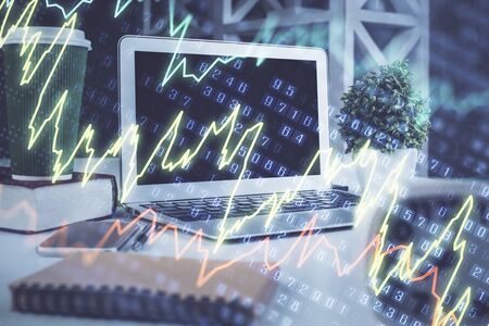 Stock market graph on background with desk and personal computer. Multi exposure. Concept of financial analysis.の写真素材