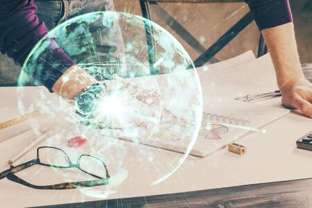 Double exposure of Man writing in notepad with business icons on background.