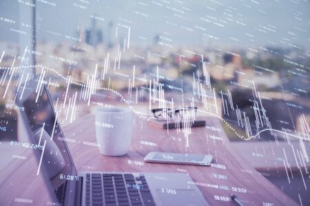 Forex market chart hologram and personal computer background. Double exposure. Concept of investment.の写真素材