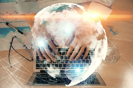 Multi exposure of businessman working on laptop on background. International business hologram in front. Concept of success.の写真素材