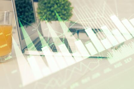 Forex graph hologram on table with computer background. Multi exposure. Concept of financial markets.の写真素材
