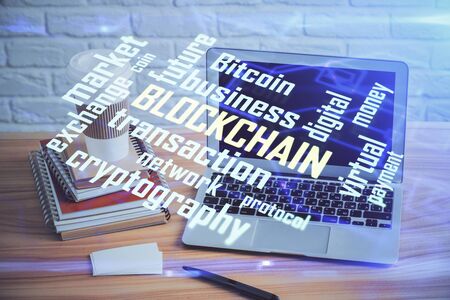 Multi exposure of blockchain theme hologram and table with computer background. Concept of bitcoin crypto currency.の写真素材