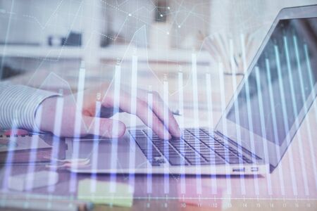 Double exposure of stock market graph with man working on laptop on background. Concept of financial analysis.の写真素材