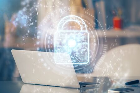 Double exposure of desktop with computer and lock icon hologram. Concept of data safety.