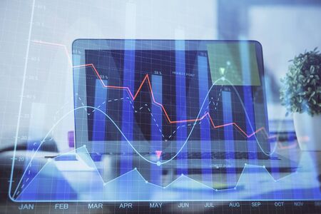 Stock market graph on background with desk and personal computer. Multi exposure. Concept of financial analysis.の写真素材