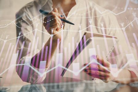 Financial chart drawn over hands taking notes background. Concept of research. Multi exposureの写真素材