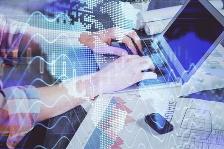Double exposure of stock graph with businessman typing on computer in office on background. Concept...
