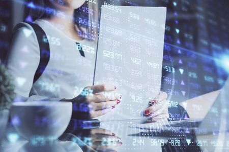Double exposure of hands making notes with forex chart huds. Stock market concept.