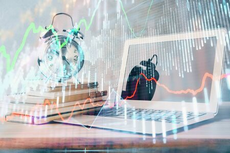 Forex market chart hologram and personal computer background. Multi exposure. Concept of investment.の写真素材