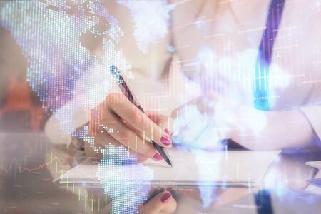 Double exposure of hands making notes with forex chart huds. Stock market concept.の写真素材