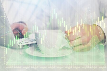 Double exposure of graph with man typing on computer in office