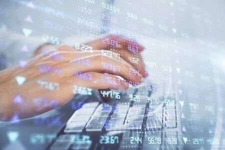 Multi exposure of graph with man typing on computer in office