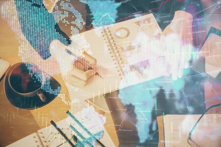 Double exposure of hands making notes with forex chart huds. Stock market concept.の写真素材