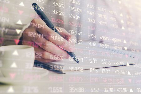 Forex chart displayed on womans hand taking notesの写真素材