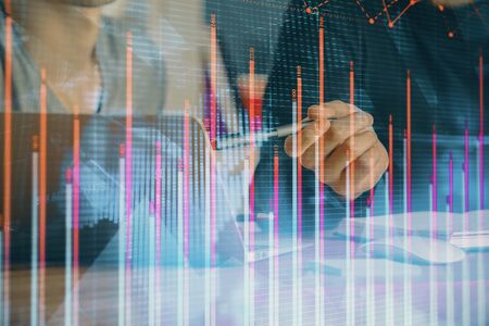 Forex graph with businessman typing on computer in office on background. Concept of analysis. Double...