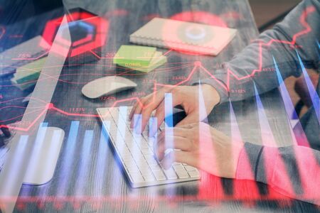 Stock graph with businessman typing on computer in office on background. Concept of analysis. Double exposure.の写真素材