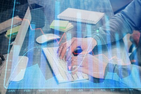Stock graph with businessman typing on computer in office on background. Concept of analysis. Double exposure.の写真素材