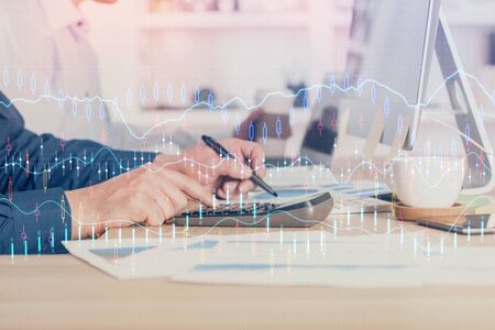 Forex graph with businessman working on computer in office on background. Concept of hardworking....