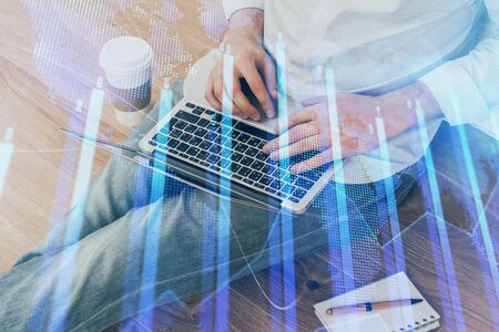 Forex graph with businessman working on computer in office on background. Concept of analysis. Double exposure.の写真素材