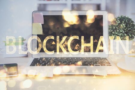 Multi exposure of blockchain theme hologram and table with computer background. Concept of bitcoin crypto currency.の写真素材