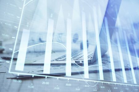 Forex graph hologram on table with computer background. Multi exposure. Concept of financial markets.の写真素材