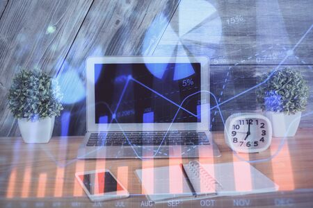 Double exposure of chart and financial info and work space with computer background. Concept of international online trading.の写真素材
