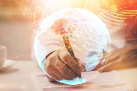 Double exposure of Man writing in notepad with business icons on background. Concept of international business.の写真素材