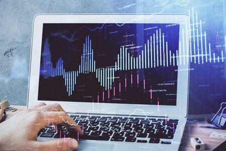 Forex graph with businessman working on laptop on background. Concept of hardworking. Multi...