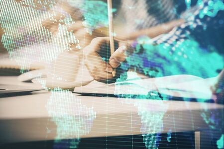 Double exposure of Man writing in notepad with business icons on background.の写真素材