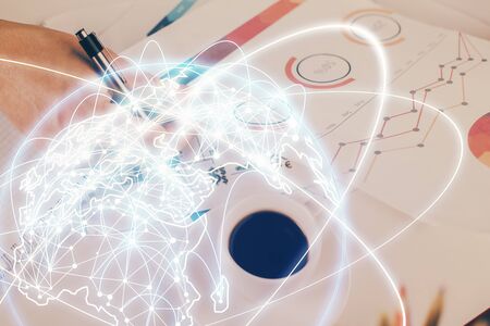 Double exposure of Man writing in notepad with business icons on background.の写真素材