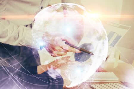 Double exposure of Man writing in notepad with business icons on background.の写真素材