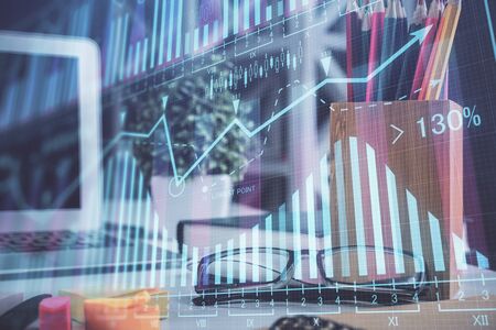 Financial chart hologram with glasses on the table background. Concept of business. Double exposure.の写真素材