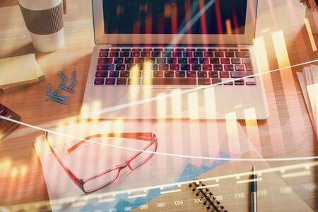 Financial market graph hologram and personal computer on background. Multi exposure. Concept of forex.の写真素材