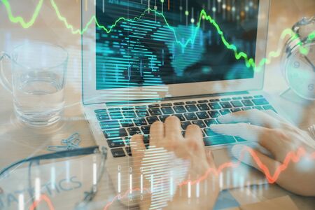 Double exposure of market chart with man working on computer on background. Concept of financial analysis.の写真素材