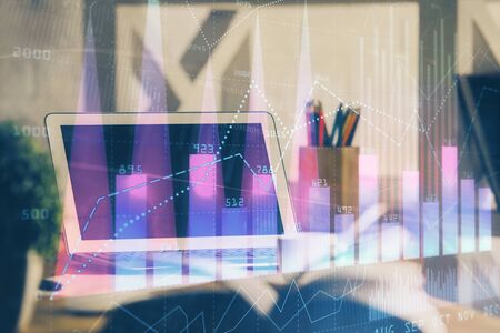 Forex market graph hologram and personal computer on background. Multi exposure. Concept of investment.の写真素材