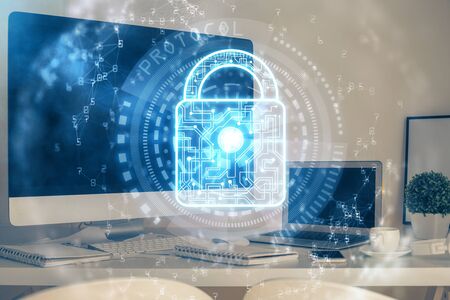 Double exposure of desktop with computer and lock icon hologram. Concept of data safety.