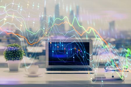 Stock market graph on background with desk and personal computer. Double exposure. Concept of financial analysis.の写真素材