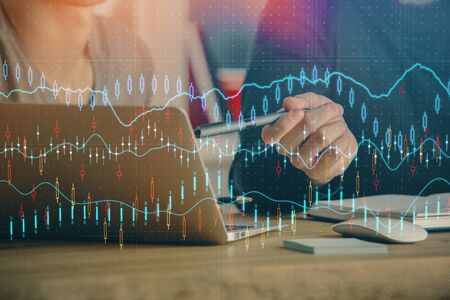 Forex graph with businessman typing on computer in office on background. Concept of analysis. Double...