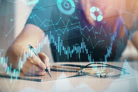 Multi exposure of womans hands making notes with forex graph hologram. Concept of technical...