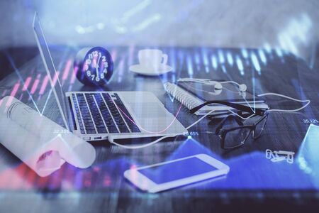 Forex graph hologram on table with computer background. Multi exposure. Concept of financial markets.の写真素材