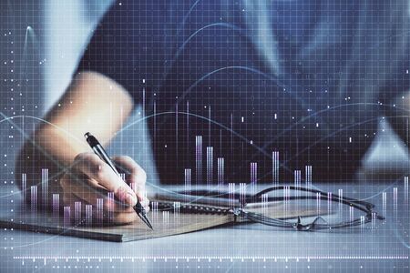 Multi exposure of womans hands making notes with forex graph hologram. Concept of technical...