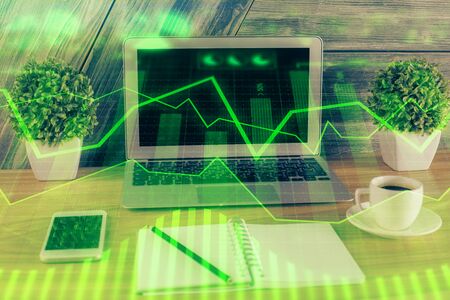 Double exposure of graph and financial info and work space with computer background. Concept of international online trading.の写真素材