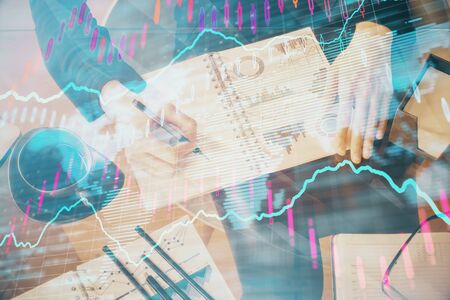 Double exposure of hands making notes with forex chart huds. Stock market concept.の写真素材
