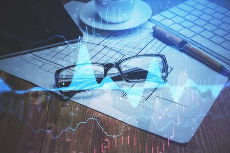 Financial chart hologram with glasses on the table background. Concept of business. Double exposure.の写真素材