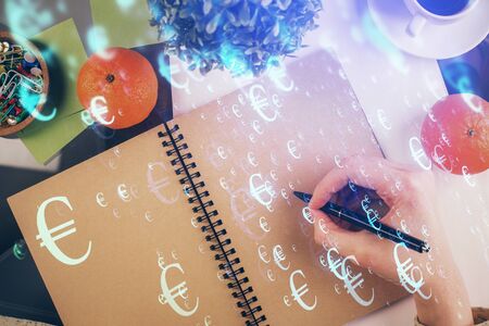 Forex chart hologram on hand taking notes background. Concept of analysis. Double exposureの写真素材