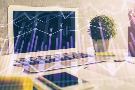 Forex market chart hologram and personal computer background. Double exposure. Concept of investment.の写真素材