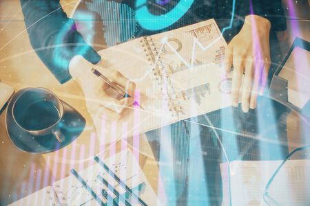 Double exposure of hands making notes with forex chart huds. Stock market concept.の写真素材