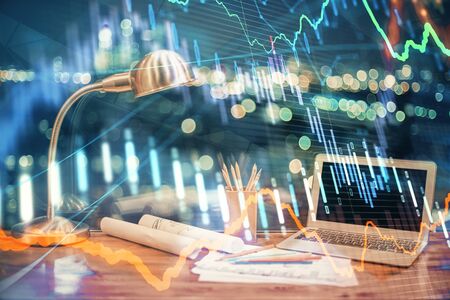 Financial chart drawing and table with computer on background. Multi exposure. Concept of international markets.の写真素材