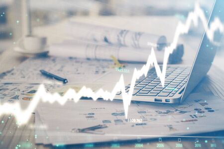Stock market graph and table with computer background. Double exposure. Concept of financial...